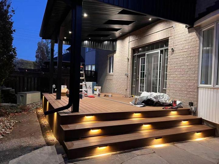Covered composite deck with steps and built-in lighting at dusk