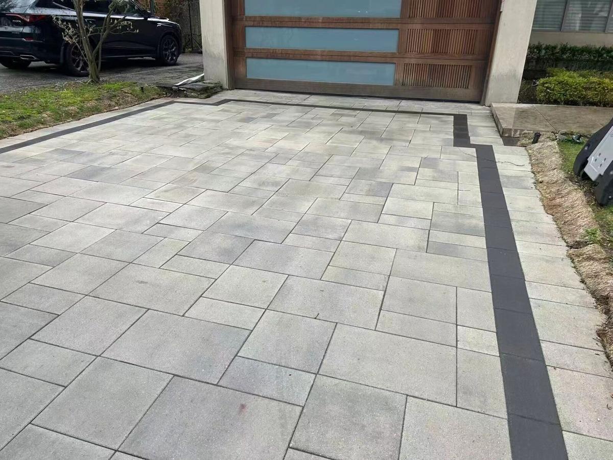 Wide interlock driveway leading to a modern garage