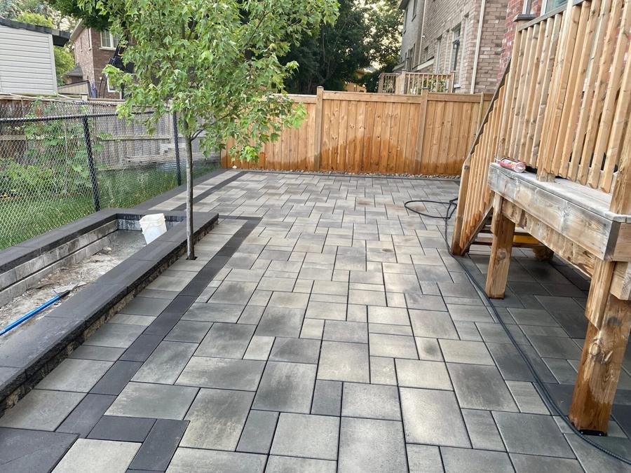 Grey slab patio with a built-in bench and raised bed