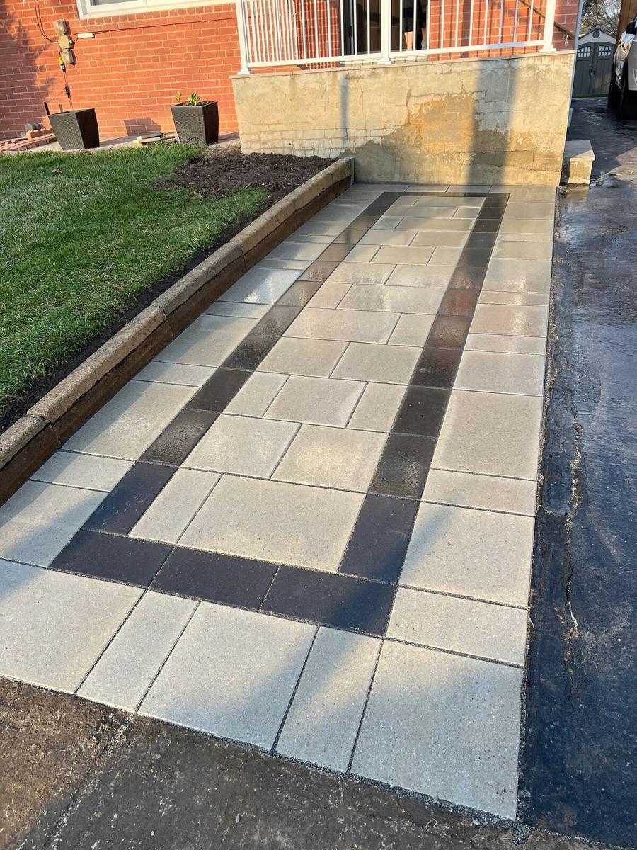 Light paver walkway with a dark banded border