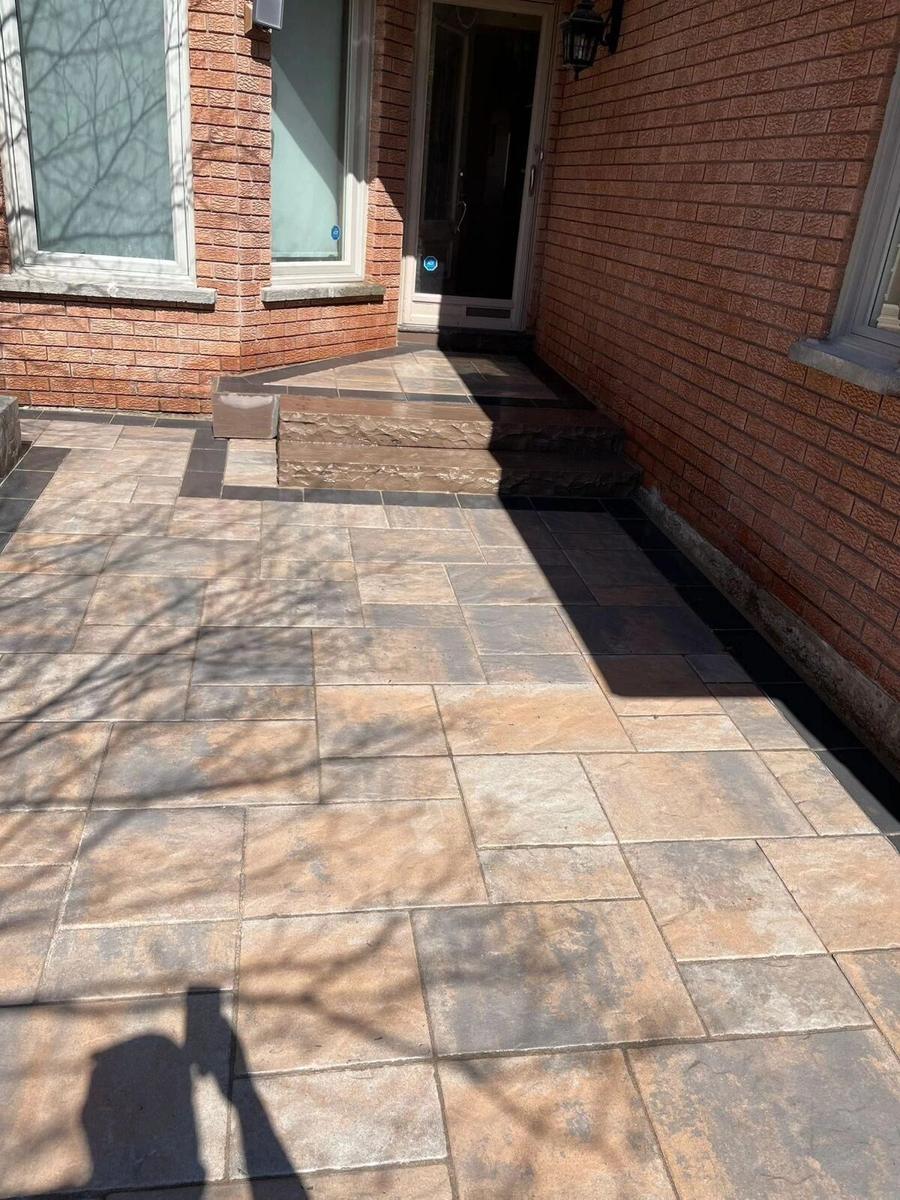 Patterned interlock walkway alongside a brick home