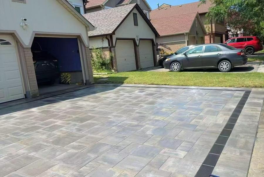 Multi-toned paver driveway with a charcoal banded border in front of a double garage