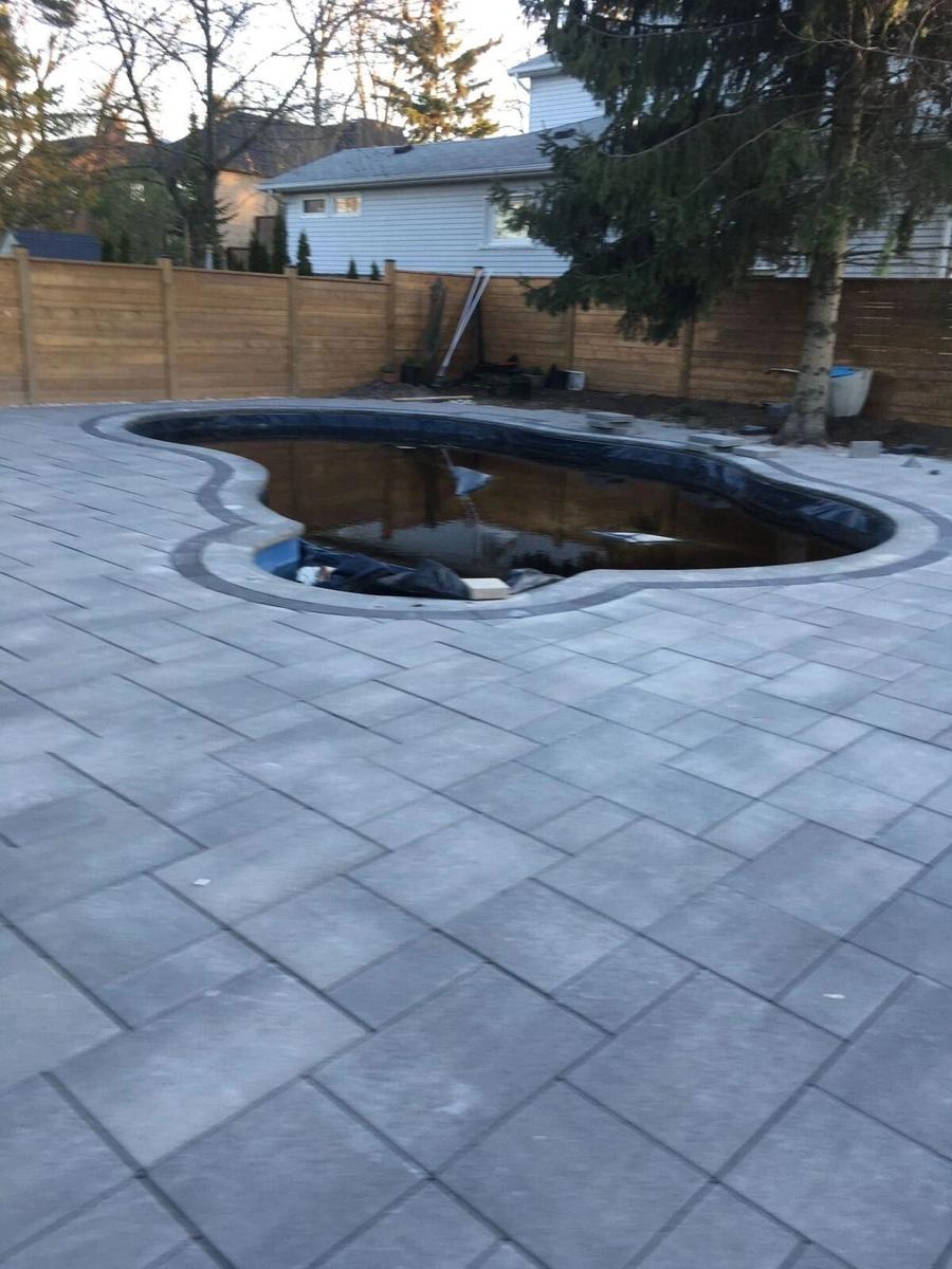 Landscaped pond and water feature edged into a paver patio