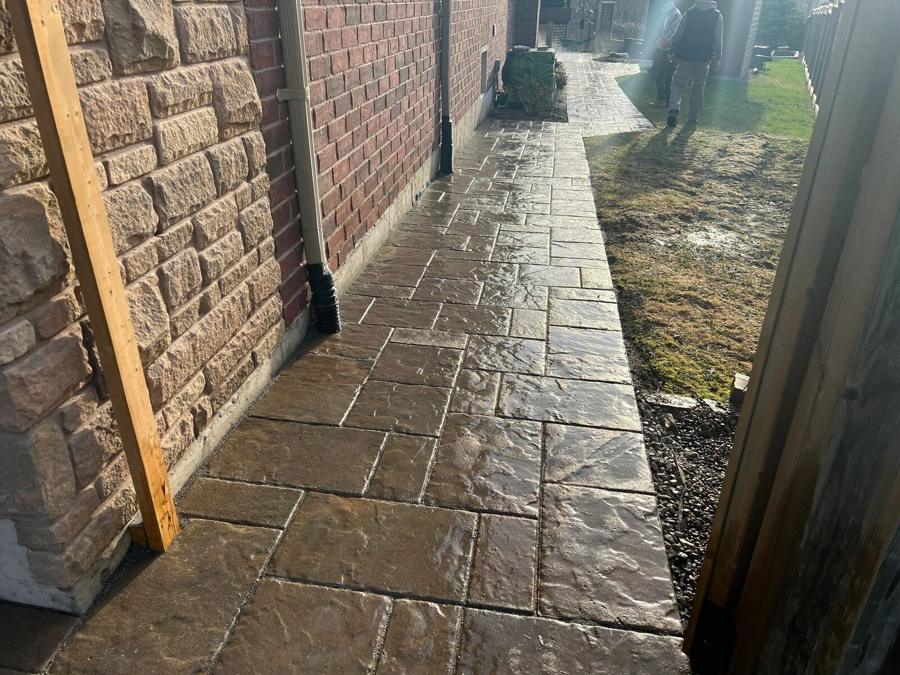 Natural flagstone walkway running alongside a brick home