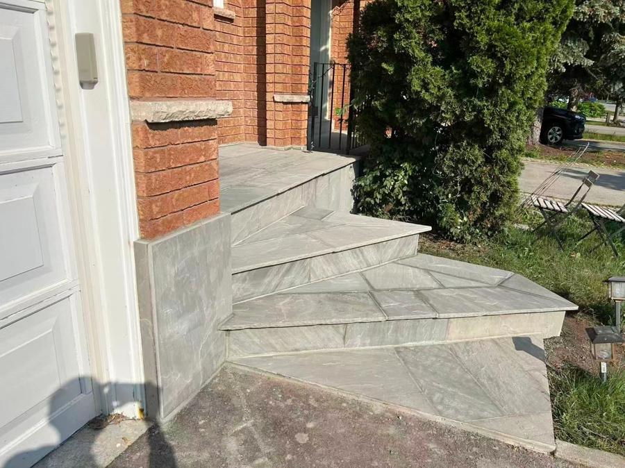 Fan-shaped stone entrance steps beside a brick home