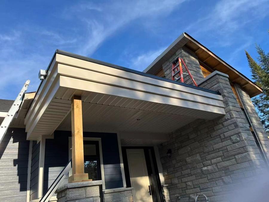 Covered porch roof structure against a blue sky