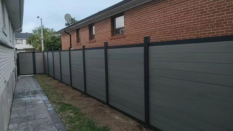 Composite privacy fence with a paver walkway down a side yard