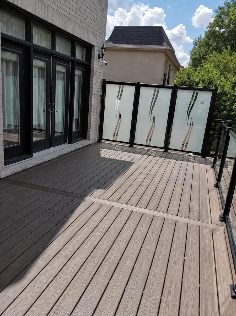 Composite deck with patterned frosted-glass privacy screens and a black-framed glass railing